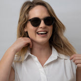 Woman wearing clear grey frame sunglasses with polarised lenses