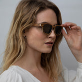 Woman wearing  Eco conscious wooden sunglasses with light coloured wood looking sideways