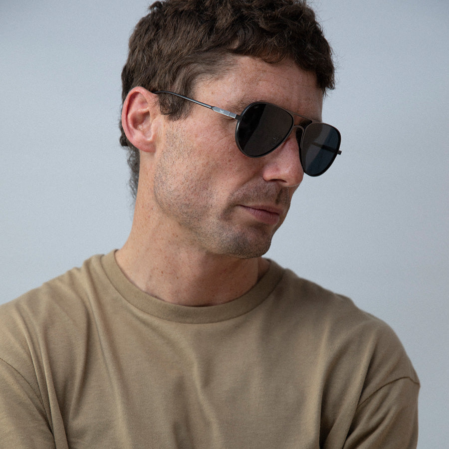 Man wearing aviator sunglasses with polarised lenses looking down